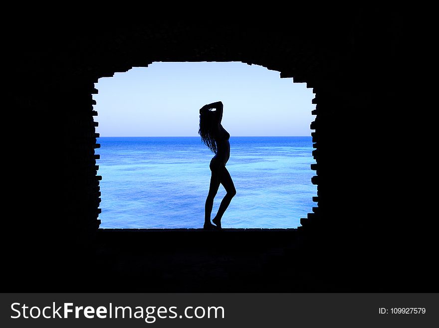 Silhouette of Woman Standing Between Walls