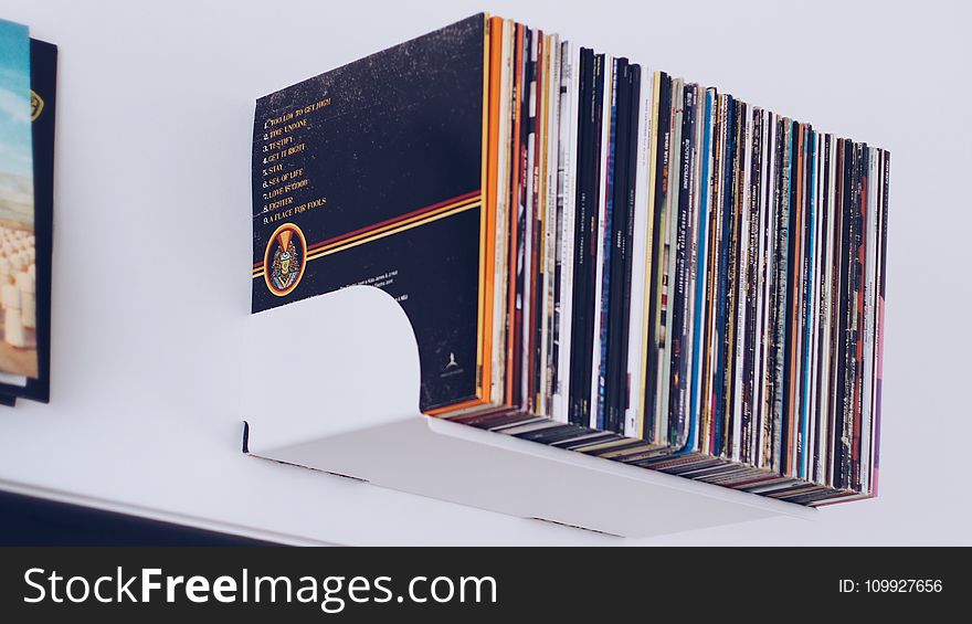 Assorted Book Hanging on White Painted Wall