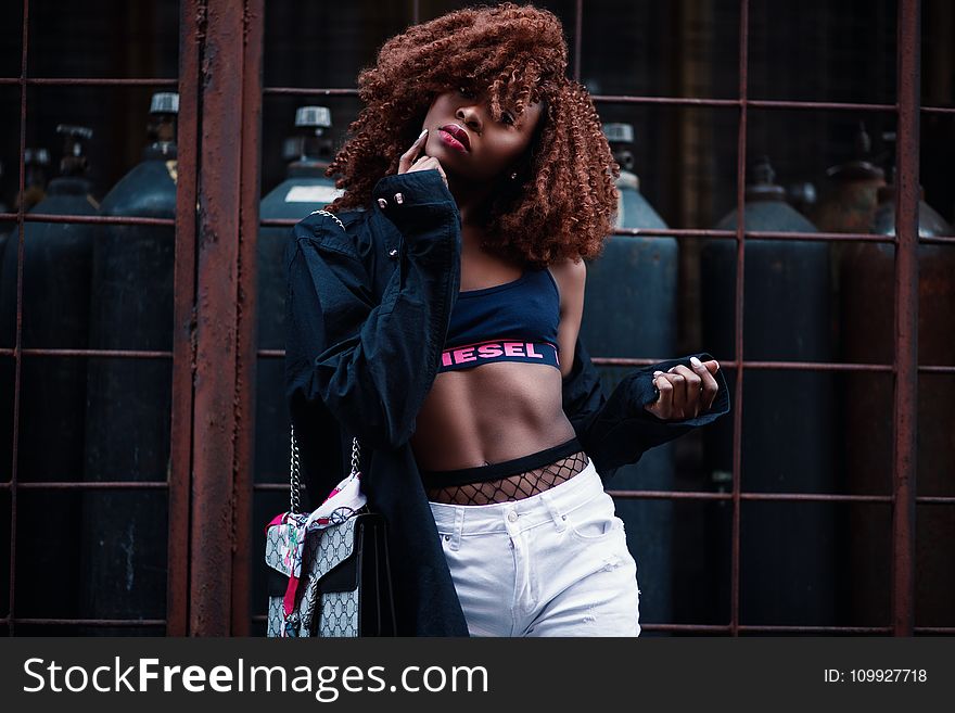 Woman Wearing Black And Pink Diesel Sports Bra With Black Jacket And White Bottoms Outfit