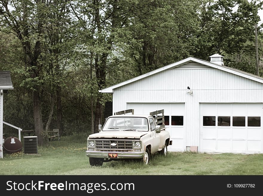 Gray Chevrolet Car Parked Near White Shed