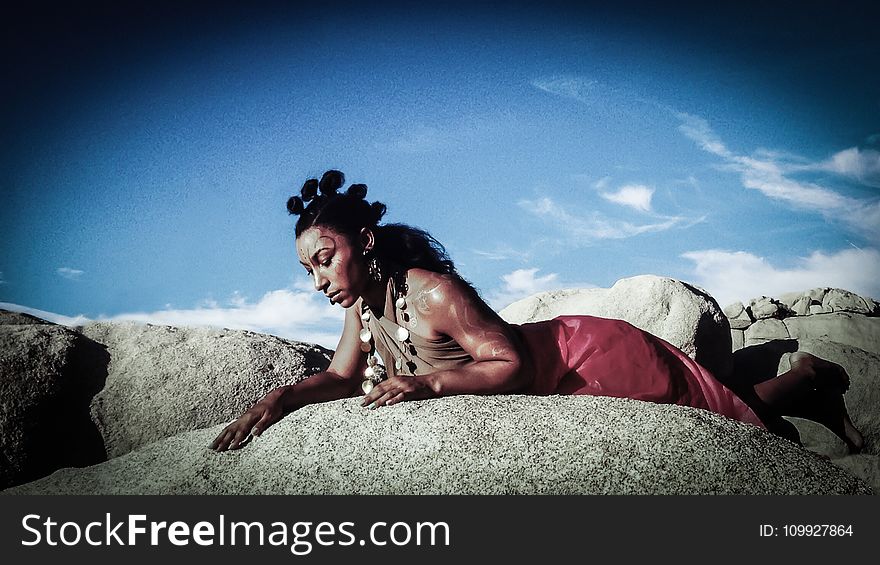Woman Posing on Top of Stone Under Blue Sky