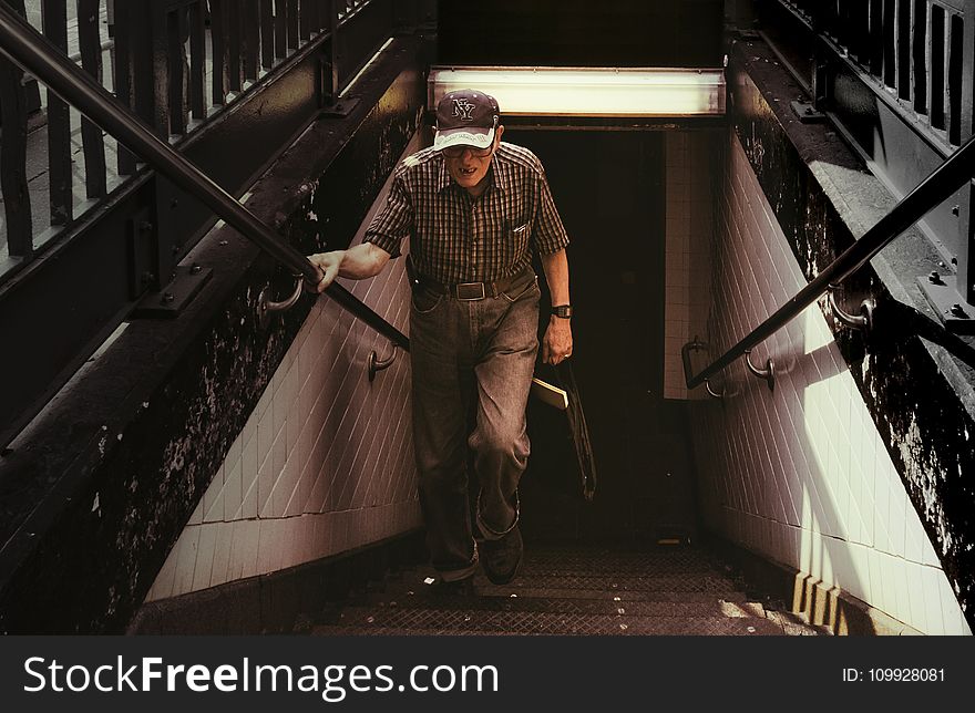 Man in Collared Shirt and Gray Pants Walking on Stairs