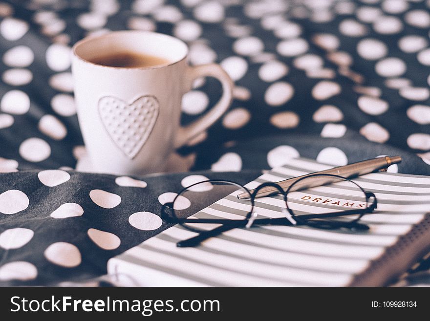 Close-up Photography Of Eyeglasses On Top Of The Notebook