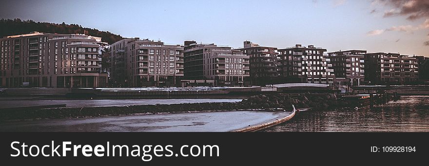 Landscape Photography of Body of Water Beside High Rise Building during Golden Hour