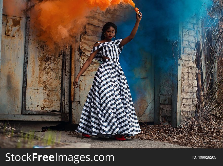 Woman in Black and White Plaid Dress Holding Torch