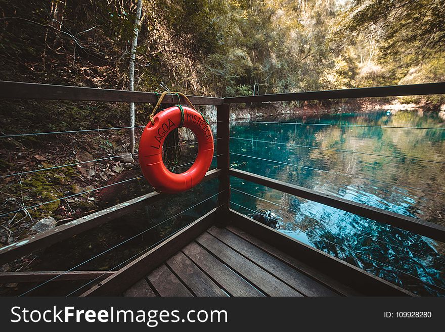 Red Life Buoy Hanging On Brown Wooden Balcony