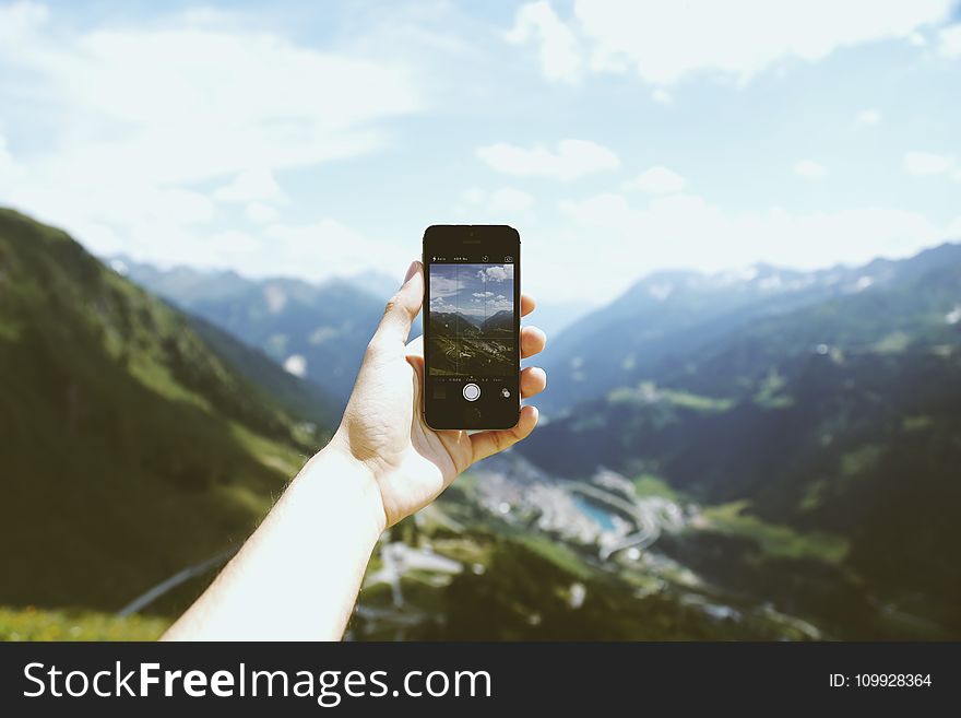 Person Holding Space Gray Iphone 5s Taking Picture of Mountains