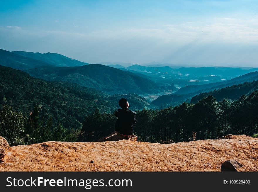Person Sitting By The Cliff