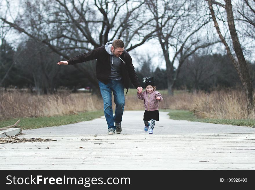 Man and Girl Running on Asphalt Road