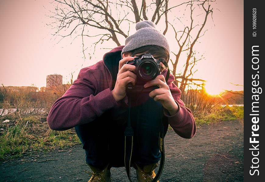 Man in Red Jacket Holding Black Dslr Camera