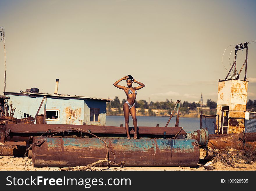 Woman Standing on Brown Steel Container Wearing Two-piece Bikini