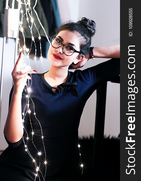 Woman Wearing Black Knit Elbow-sleeved Top Touching Mini String Lights