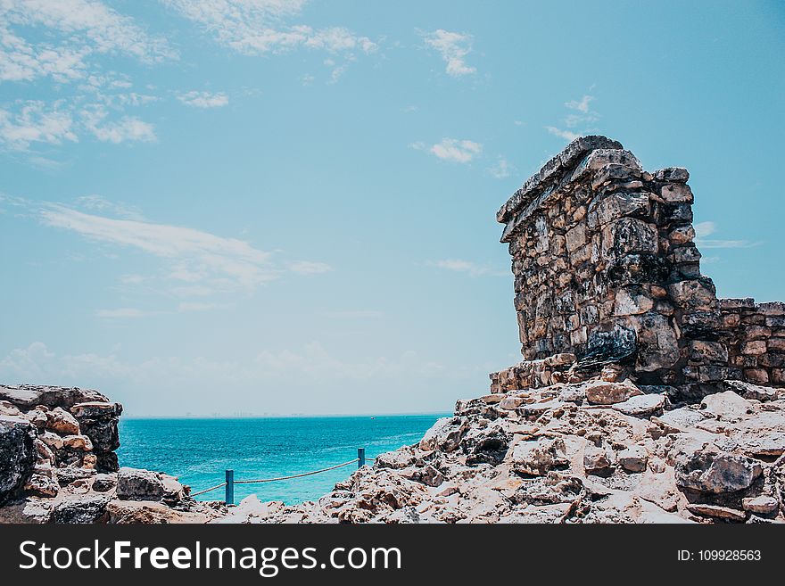 Rocky Terrain Near Sea Under Blue Skies