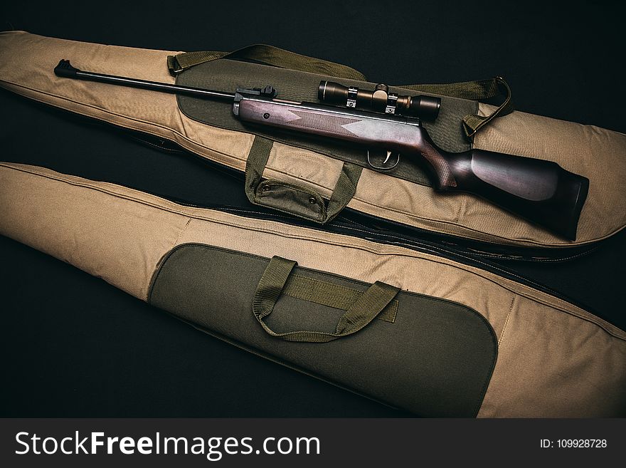 Black Rifle With Scope And Brown Gig Bag