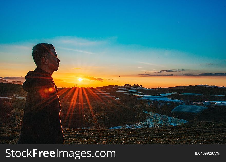 Photo of a Man Wearing Hoodie During Sunset