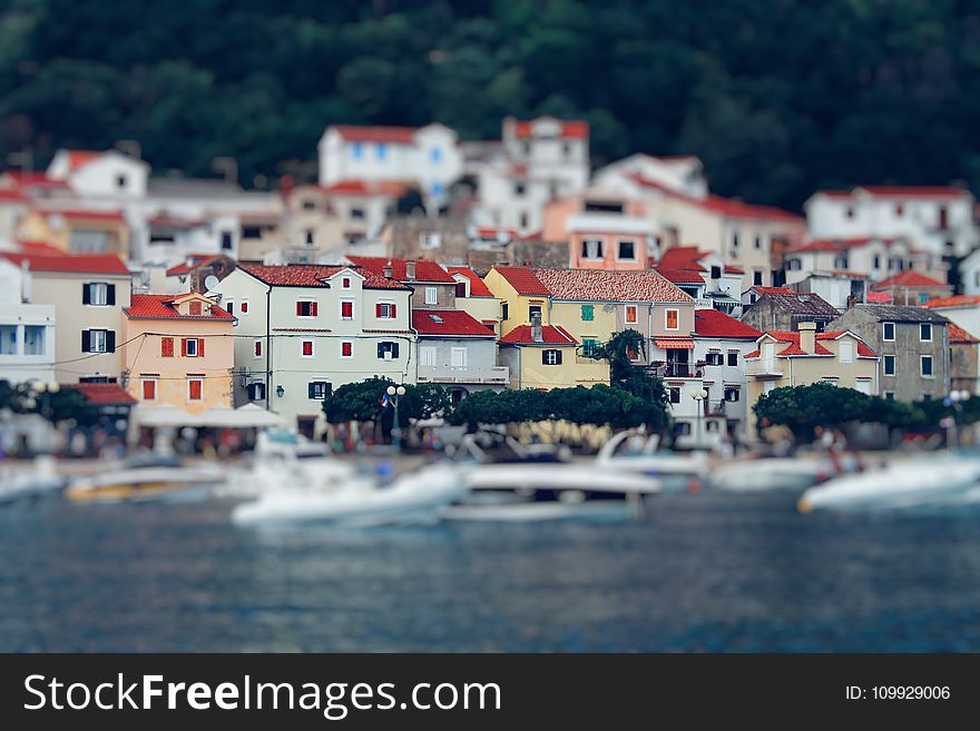 Tilt Shift Lens Photography of Red Roof House Near the Body of Water