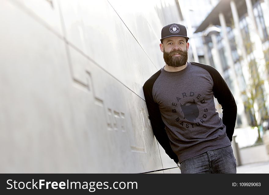 Man Leaning Against the White Concrete Wall