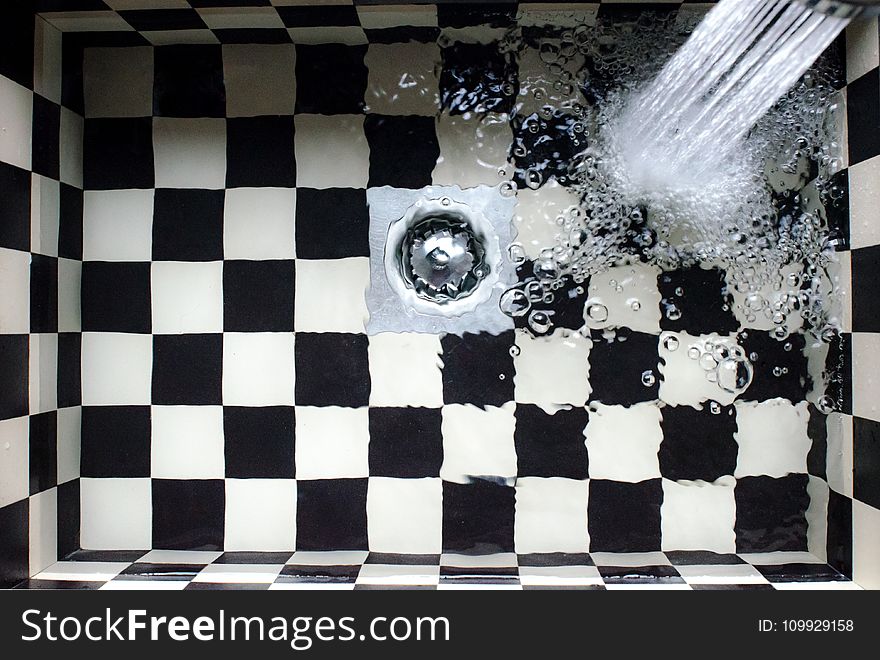 Water Flowing on White and Black Checked Bath Tub