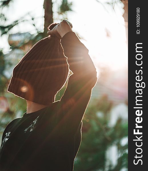 Person Covering Its Face With Knitted Hat