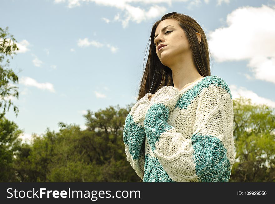Woman in White and Teal Crochet Dress Under Cloudy Sky