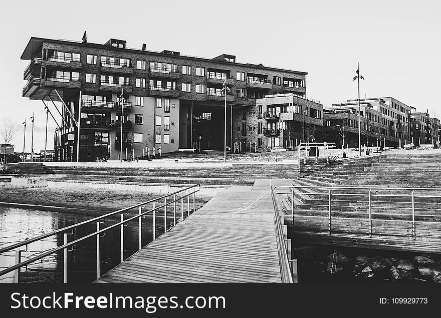 Gray Scale Photo of a Dock Near a Building