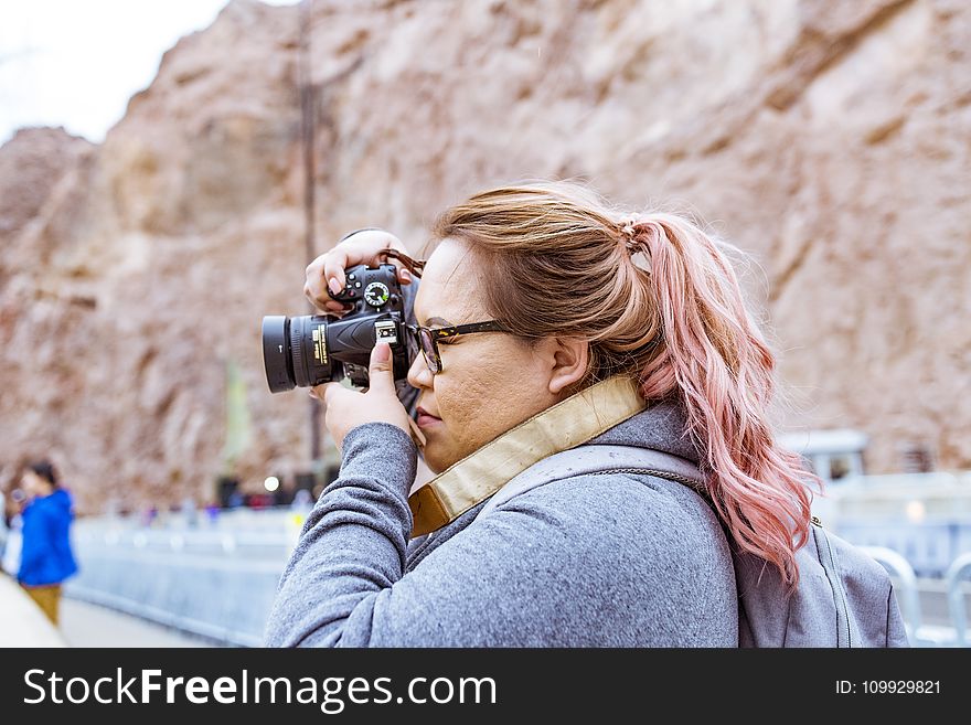 Woman Wearing Gray Jacket Using Black Dslr Camera
