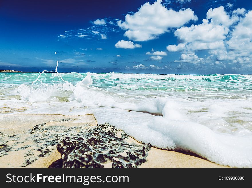 Landscape Photography of Beach With Raging Waves Under Clear Skies