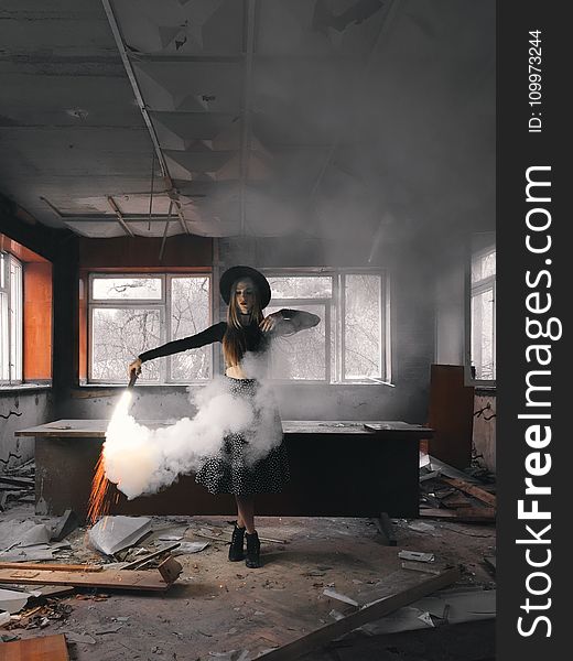 Woman Holding Smoke Flare Standing Front of Table Inside House