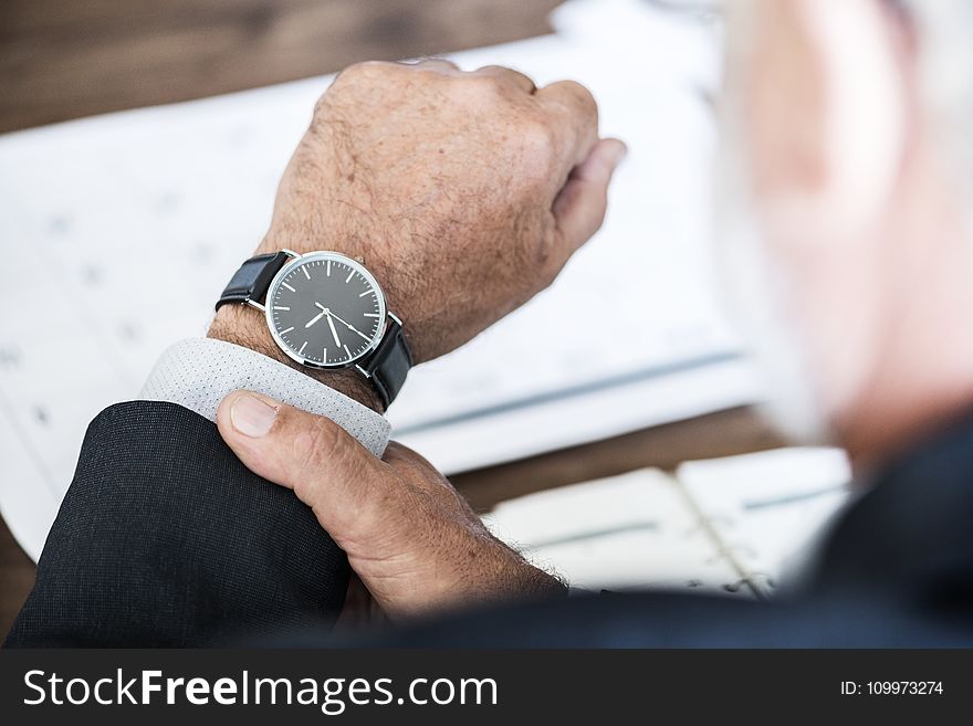 Selective Focus Photo of a Person Wearing Round Watch at 9:36
