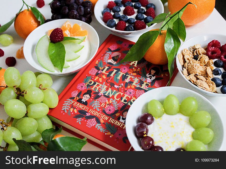 Fruits on Plates Beside Red Book