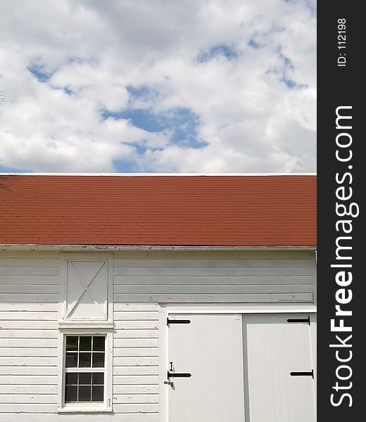 This is a contrast shot of a white barn and some puffy clouds against a nice blue sky. This is a contrast shot of a white barn and some puffy clouds against a nice blue sky.