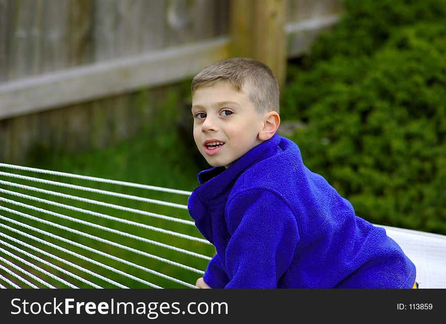 Young Boy Outdoors Cllimbing on a Hammock. Young Boy Outdoors Cllimbing on a Hammock