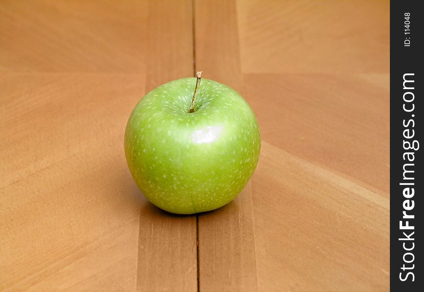 Granny smith apple sitting on kitchen table.