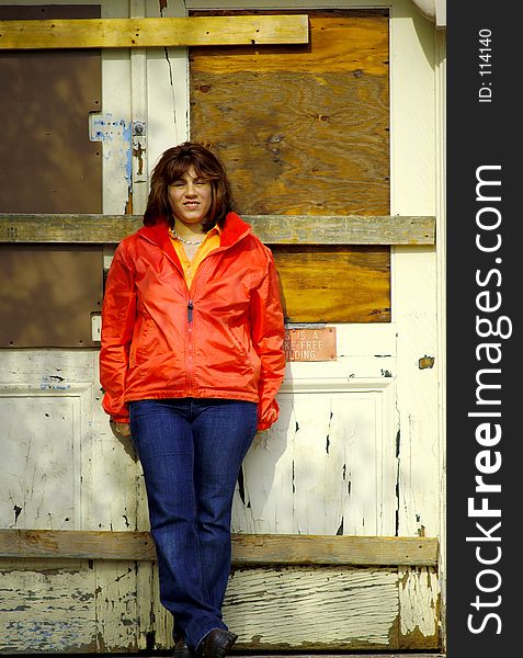 Woman Standing By a Boarded Up Doorway