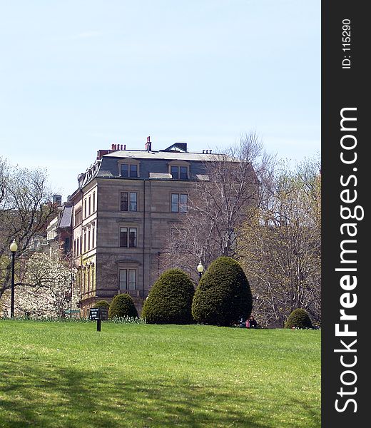 View of old brownstone building from the public gardens in boston massachusetts. keep off the grass sign in early spring. View of old brownstone building from the public gardens in boston massachusetts. keep off the grass sign in early spring