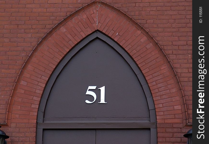 The number fifty one in metal numbers on archway above door, surrounded by bricks, easthampton massachusetts. The number fifty one in metal numbers on archway above door, surrounded by bricks, easthampton massachusetts