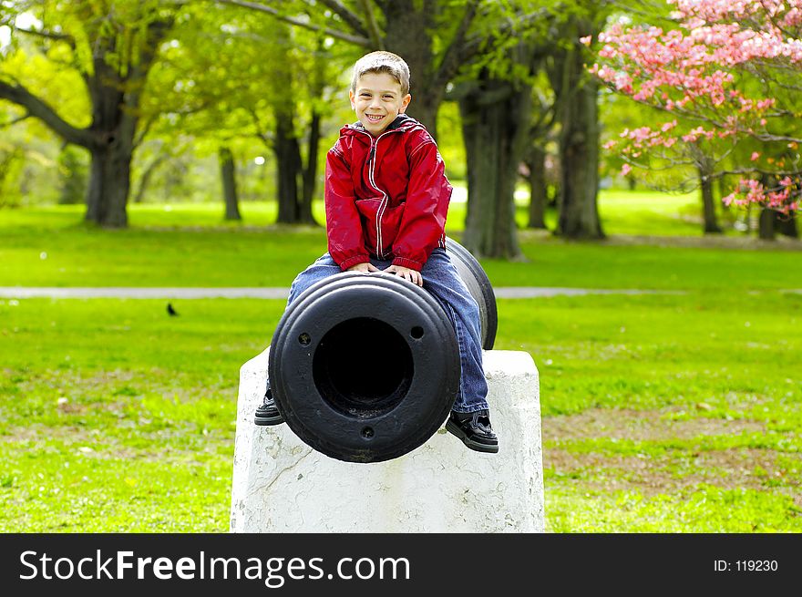 Young Boy SItting on a Cannon. Young Boy SItting on a Cannon