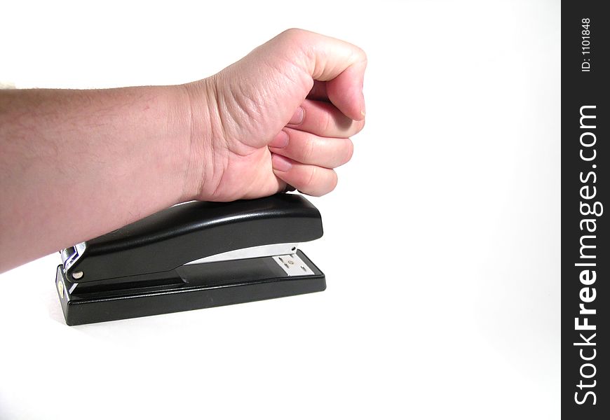 Large hand pounding a stapler in frustration. Large hand pounding a stapler in frustration