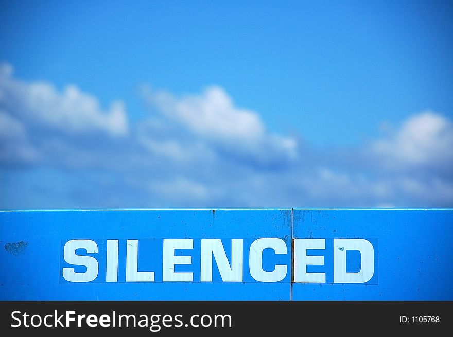 Silenced sign writen on top of machine and sky behind