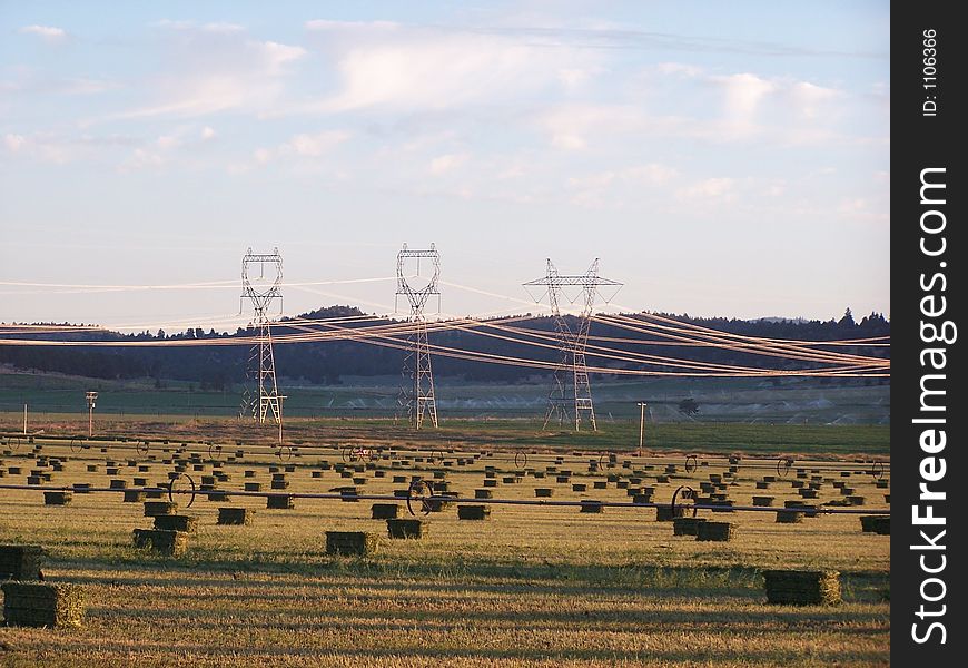 Power Transmission Lines over a field of bailed hay. Taken in the early morning hours.