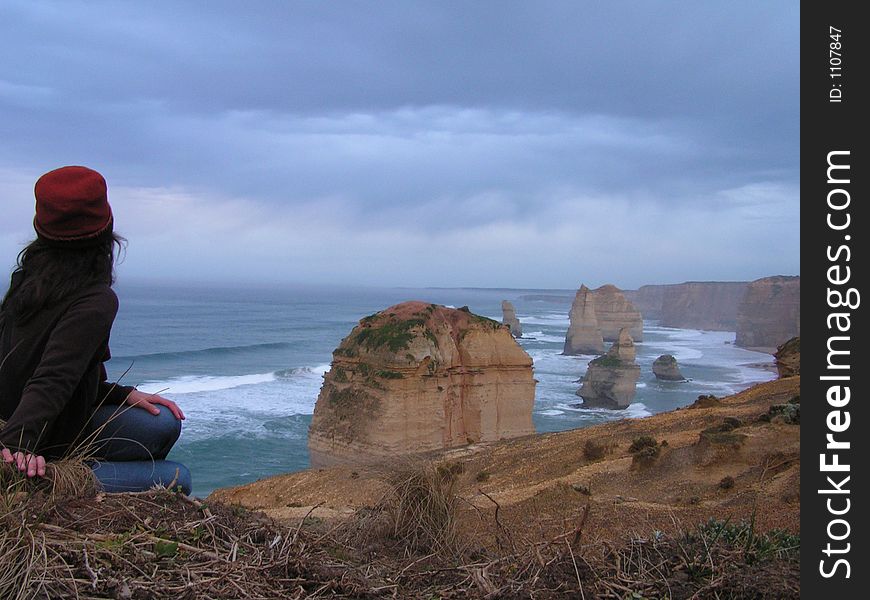 Woman sitting and watching the twelve apostles in Australia