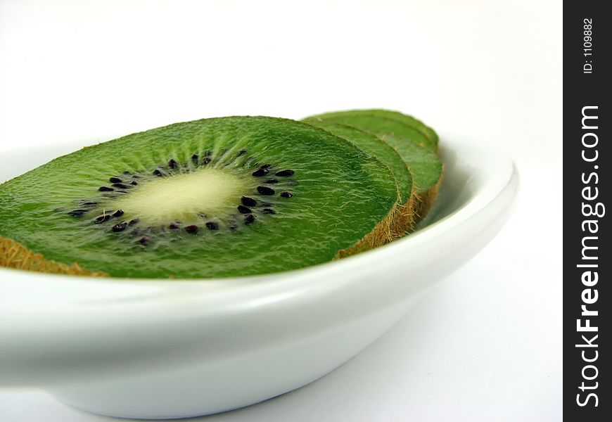 Kiwi slices on white plate, dof. Kiwi slices on white plate, dof