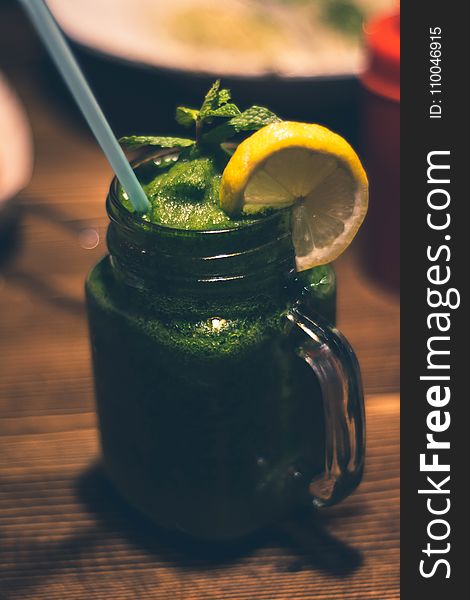 Close-up Photography of Clear Glass Mason Jar Mug With Green Juice and Sliced Citrus Toppings