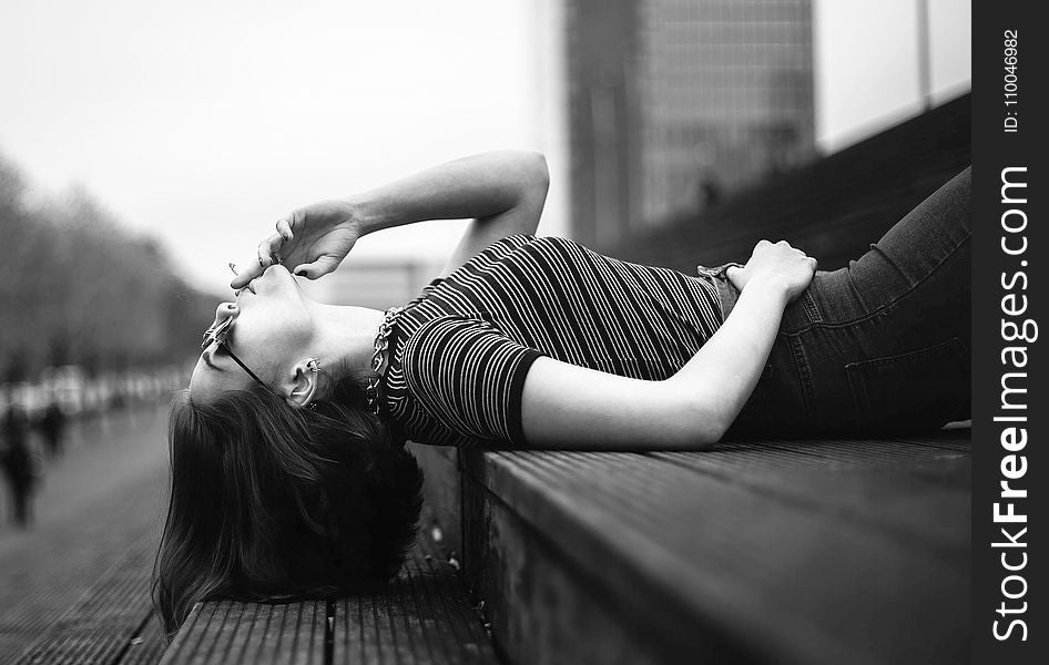 Woman Laying on Stairway Grayscale Photo