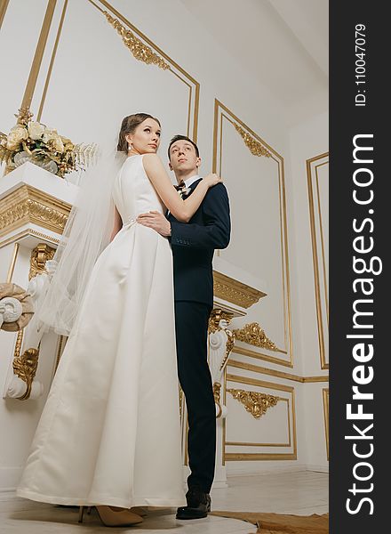 Woman Wearing White Sleeveless Bridal Gown Holding Man