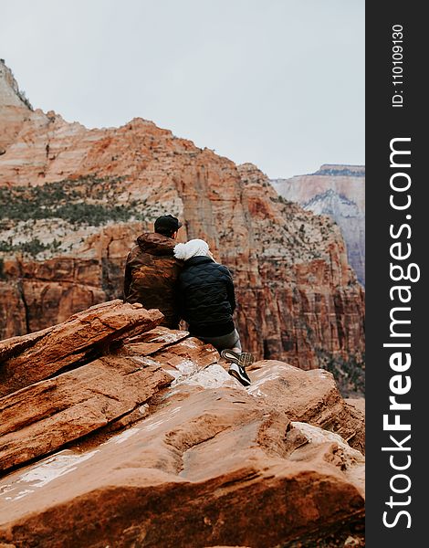 Couple Sitting on Rock Cliff