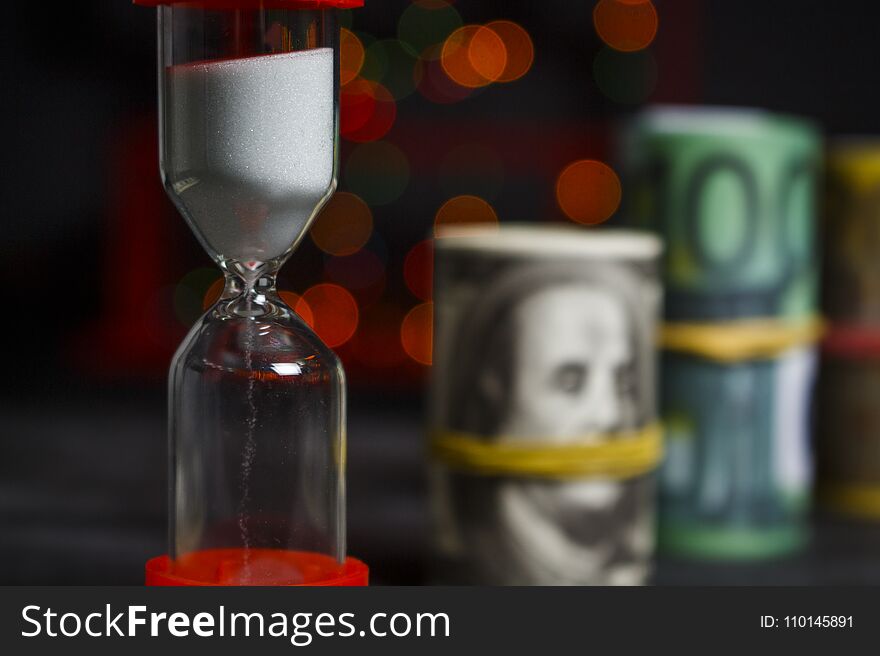 Hourglass With A Bunch Of Dollars And Euros