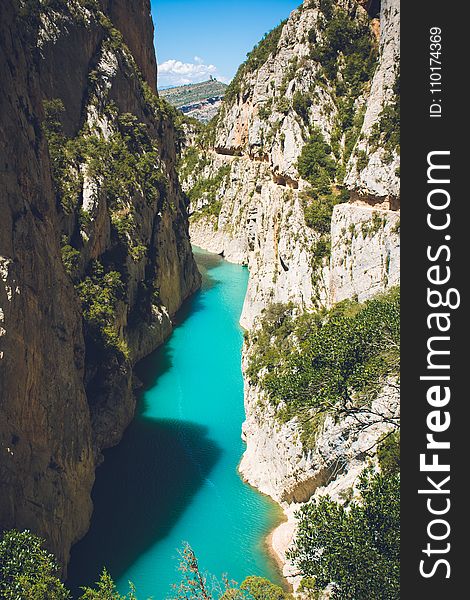 Body Of Water In Between Of Rock Formation Under Blue Sky At Daytime