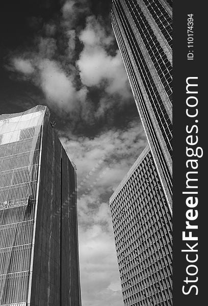 Low Angle Grayscale Photography of Buildings and Clouds