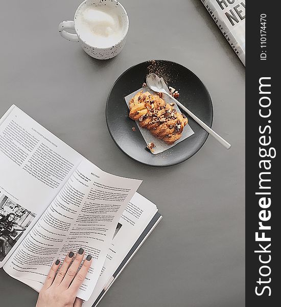 Bread on Round Black Plate Near White Ceramic Cup